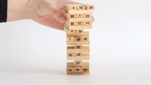 Woman and man plays jenga on white background. Family recreation and holidays concept.