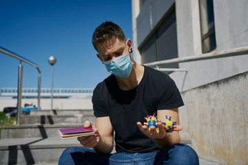 Caucasian male in medical masks with virus mock-ups and passport. Concept of not being able to travel and move around the coronavirus