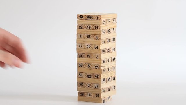 Woman and man plays jenga on white background. Family recreation and holidays concept.