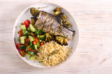 Baked sea bass fish and salad