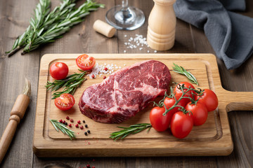 ribeye steak on a wooden board. raw meat, beef. View from above