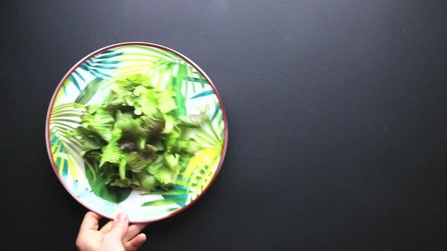 hand that prefers a plate of meat salad on a black background to use as an example for a concept