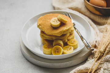 Delicious pancake with banana slices served on wooden table