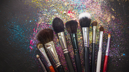 Set of makeup brushes, different makeup artist brushes, still life on the background of eyeshadow and powder,