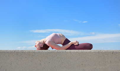 Portrait of a fit woman who practices yoga outdoors. Woman practicing asanas on a sunny day