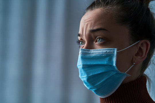 Upset Depressed Melancholy Woman In Protective Face Mask With Sad Eyes During Serious Illness, Coronavirus Outbreak And Flu Covid Epidemic. Health Problems And Life Difficulties. Copy Space