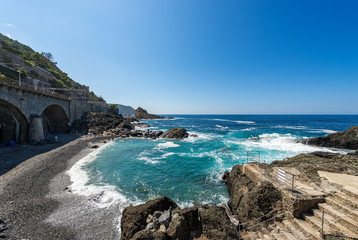 Fototapeta na wymiar Coastline with a beach, cliffs and Mediterranean Sea near the small Village of Framura, La Spezia province, Liguria, Italy, Europe
