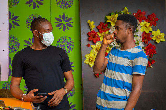 Young Black Man Wearing A Nose Mask And Preventing A Friend From Giving Him A Flu Through Cough