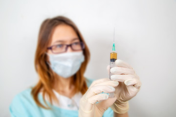 The doctor fills a syringe with medicine. Focus on an injection.