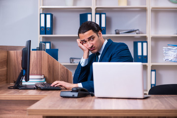Fototapeta premium Young handsome businessman working in the office