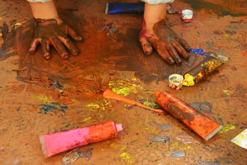 Hands of a child in paint playing on the Sun in the time of isolation background. 