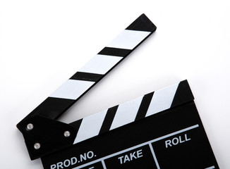 black movie clapper with white inscriptions on a white table