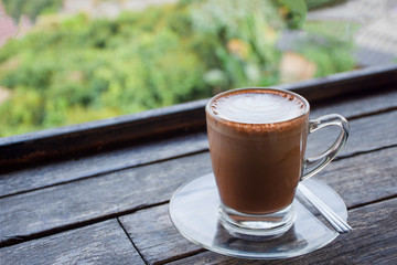 cappuccino chocolate cocoa with teaspoon isolated on wood table background. 