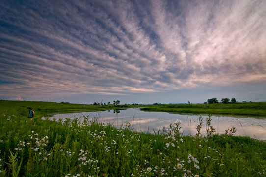 Clouds roll over a wetland conservation area at the end of a summer day.