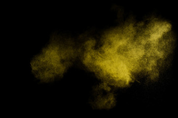 Yellow powder explosion on black background. Colored powder cloud. Colorful dust explode. Paint  Holi.