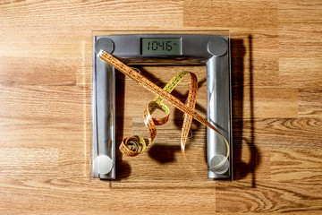 the centimeter tape is on the scale showing a lot of kilograms