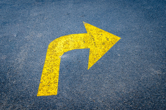 Yellow arrow on pavement pointing right