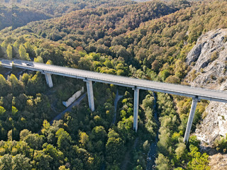 Created by dji camera. An automobile bridge on high pylons through a deep gorge in the mountains.