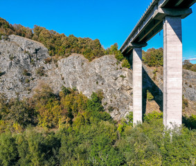 Fototapeta na wymiar Created by dji camera. An automobile bridge on high pylons through a deep gorge in the mountains.