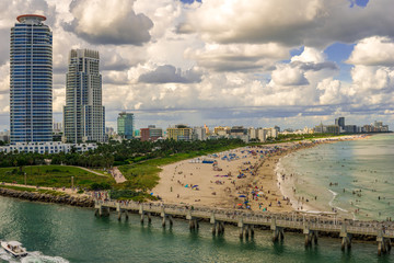 Beach coastline with a pier and cityscape background. Florida coastline waterways along the Atlantic seaboard consist of inlets, rivers, bays, sounds and some artificial canals help navigation USA.