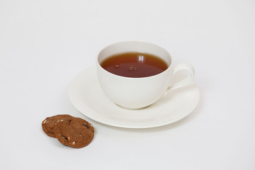 white cup with tea and cookies on a white background