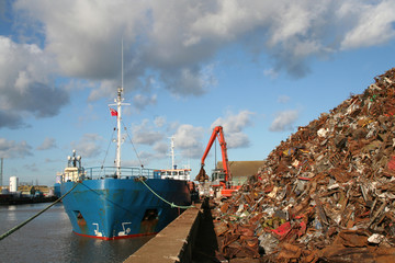 Large heap of scrap steel being loaded into a ship, landscape view