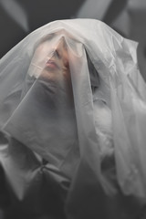 The female face is covered with white translucent cellophane. Quarantine.