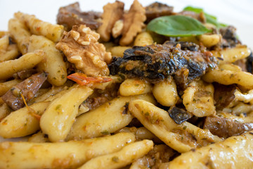 Cortecce, homemade Italian pasta with mushrooms, cherry tomatoes and walnuts. An excellent dish made in Italy