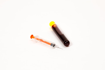 syringe for injection and test tube with blood, pills on a white background