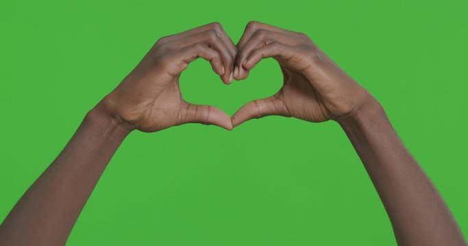 Male hands making heart symbol against chroma key background