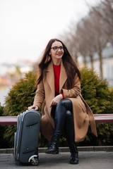 girl in a coat with a suitcase going to the landing zone
