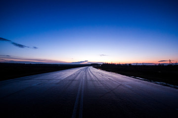 Empty asphalt road. Curved road and dark blue sky at sunset