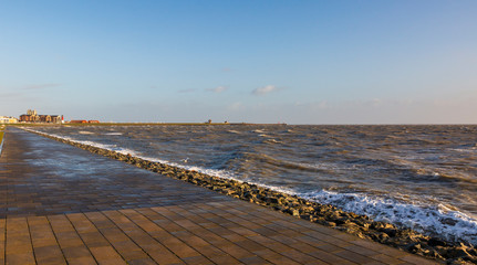 The storm pushes the normally peaceful North Sea against the coast at high tide.
