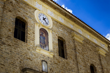Fachada antiguo edificio histórico con reloj y santo