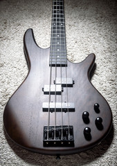 Bass electric guitar with four strings. Popular rock musical instrument. Top view of brown bass on...