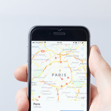 Moscow / Russia - 03.28.2019:  A hand holding a smartphone which displays city map with PARIS, FRANCE. Illustrative editorial image on an white background. Travel concept