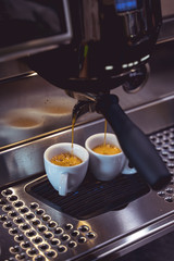Close-up of espresso pouring from coffee machine. Professional third wave coffee brewing in europe