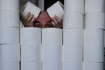Hiding from the Coronavirus behind a wall of hoarded toilet paper. © Ian