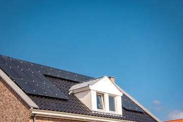 Newly build houses in the Netherlands with solar panels attached on the roof against a sunny sky...