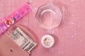 top view of cash, pills and water on table