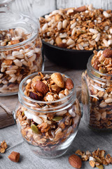 Homemade granola with different nuts and seeds in glass jars