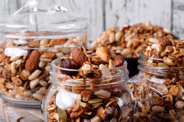 Homemade granola with different nuts and seeds in glass jars