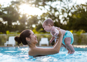 Piscina madre e hijo, bebe pequeño en la piscina - obrazy, fototapety, plakaty