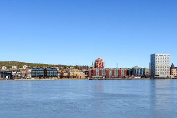 Fototapeta na wymiar Northern part of Ornskoldsvik town from sea side with a blue sky in background