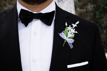 Close up de smoking de novio con azahar de boda en ceremonia