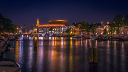 Fototapeta na wymiar Amstel Canal at night with view of the National Opera & Ballet H