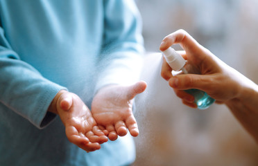 Hands with sanitizer antiseptic. Mother and child using sanitize antiseptic for hand coronavirus protection.Hygiene concept. Prevent spread of germs and bacteria and avoid infections coronavirus.