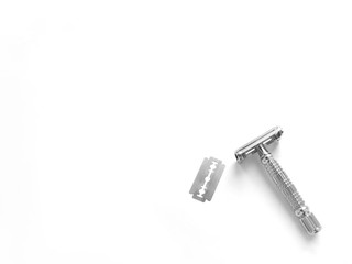 T - shaped metal razor with interchangeable blades. Butterfly safety razor. The blade is inserted inside and clamped on both sides. Zero waste. Eco-friendly consumption. White background. Minimalism