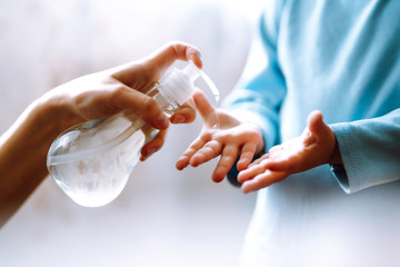 Hands with sanitizer gel. Mother and child using sanitize soap for hand coronavirus protection. Hygiene concept. Virus and illness protection, hand sanitizer in quarantine city.