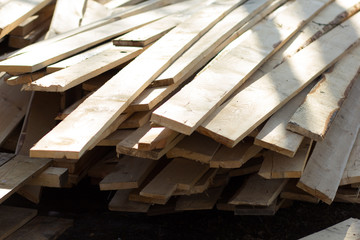 Stack of long and thin wooden planks outside